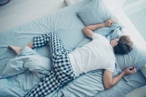 Man stretched out in bed