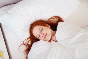 A woman with red hair sleeping peacefully