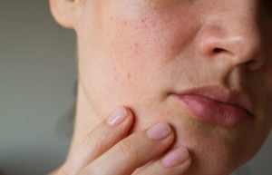 A woman places her hand near her mouth