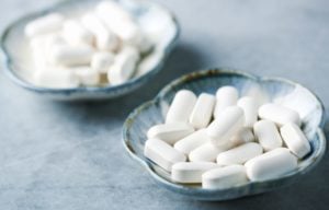 A handful of GABA supplements sit in a small tray.