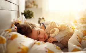 Sleeping child holding teddy bear