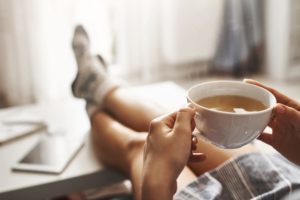 person sitting at desk with cup of coffee