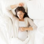 Pregnant woman sleeping in bed