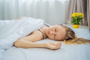 A young woman sleeping without a pillow