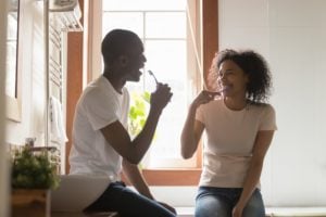 Man and Woman brushing teeth together