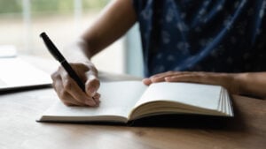 image of a woman writing in a notebook